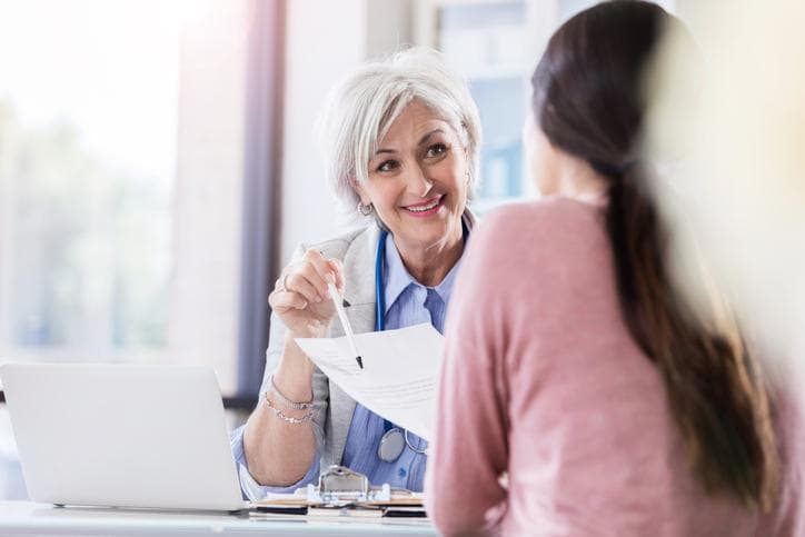 Woman speaking to another woman in clinical setting