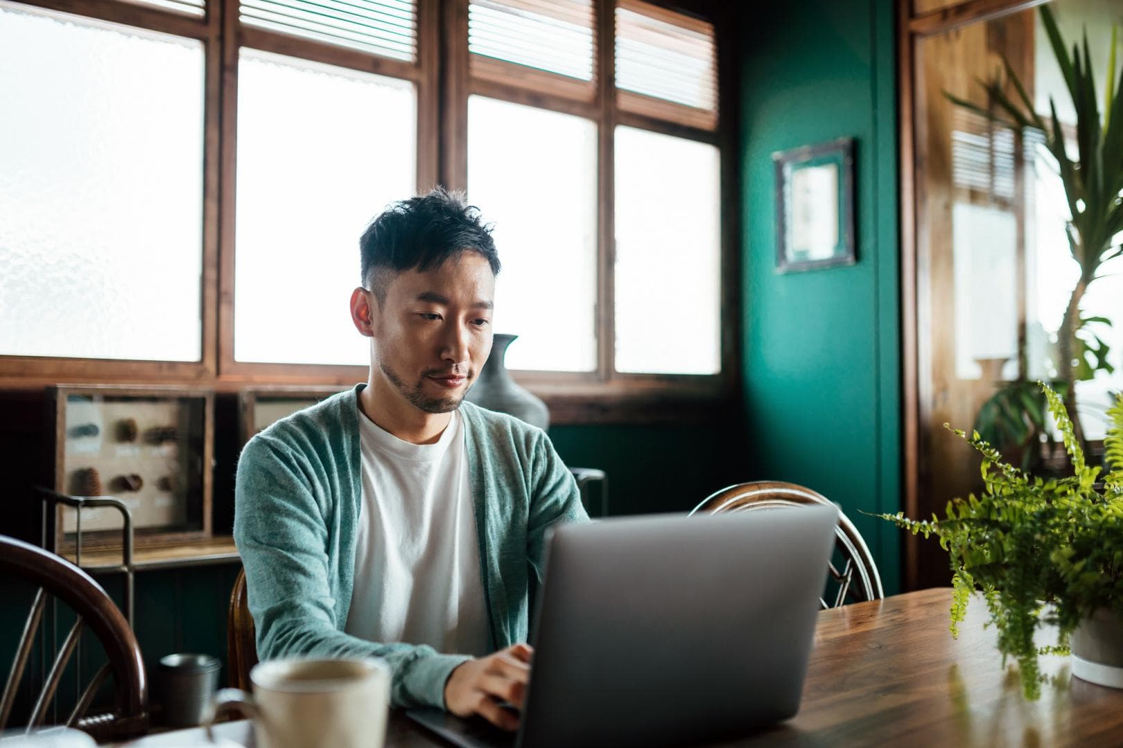 Man working at laptop at dining table