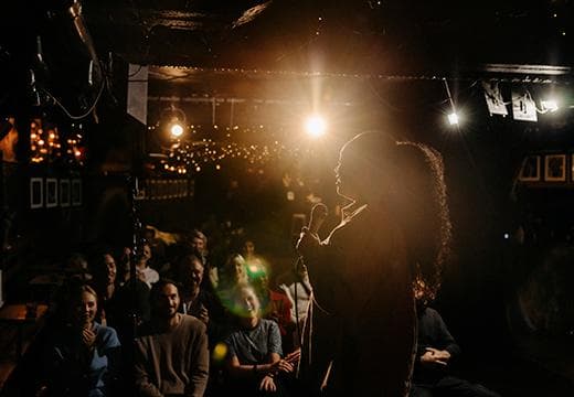 Stand up comedian in dark club, with shining light