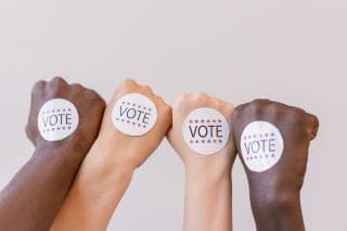 Hands with vote stickers