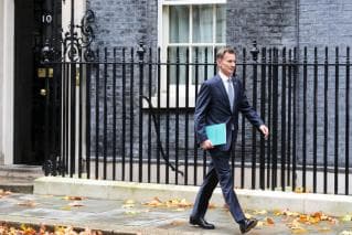 Jeremy Hunt the Chancellor walks along the road ahead of the Autumn Statement