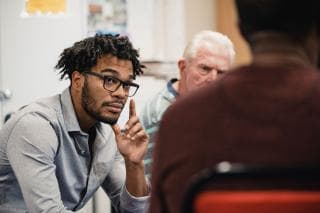 Men sit listening to one another. 