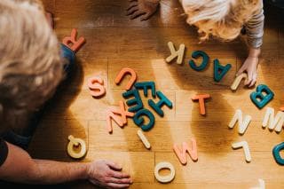 Child and parent playing with letters on the florr