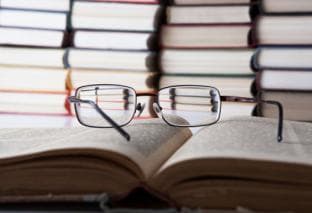 A pair of glasses on top of an open book