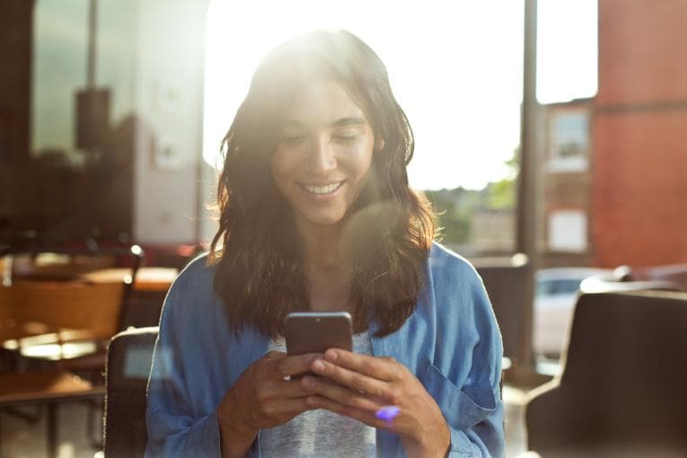 A woman looks at a smartphone