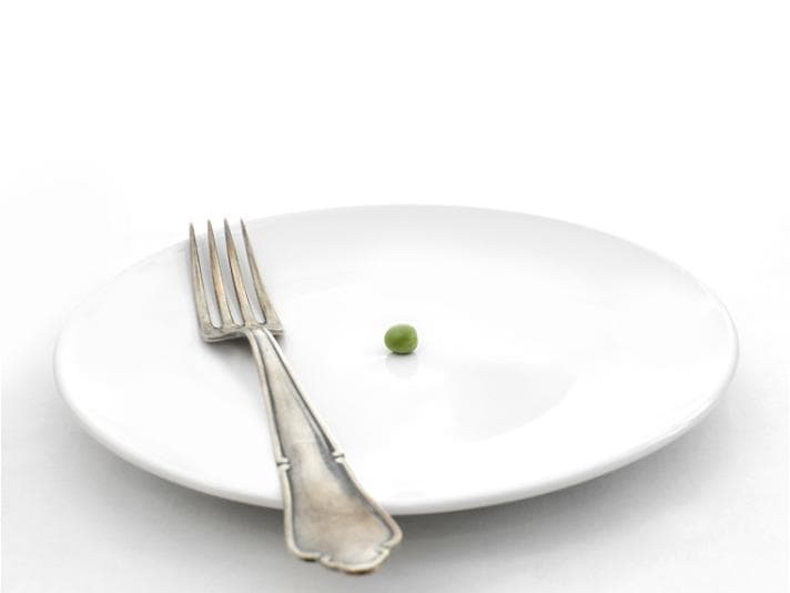 A single pea on a white plate