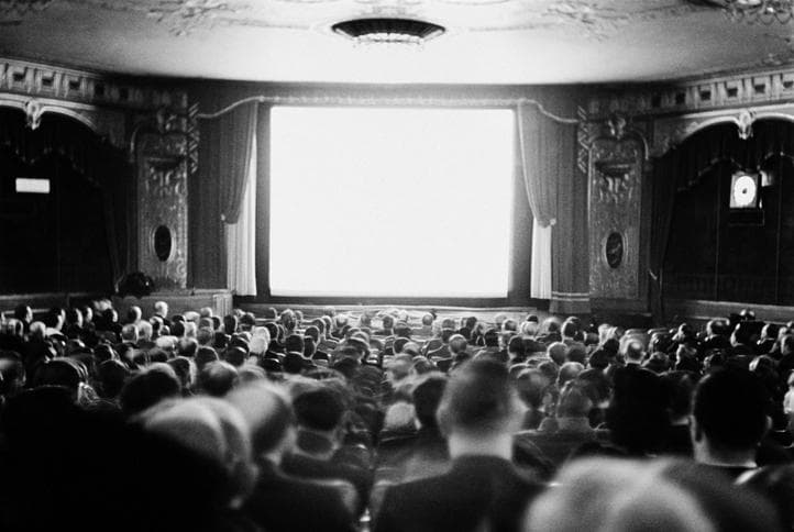 Black and white image of an audience in a movie theatre