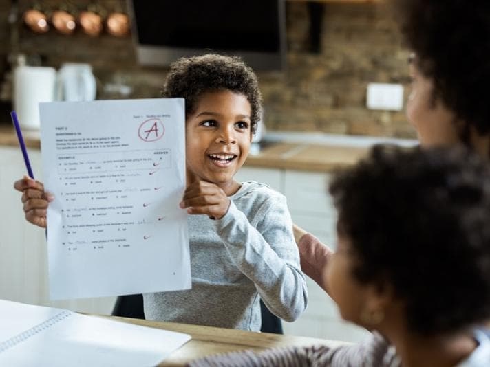 Child holding up report card