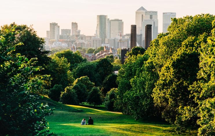 Couple sitting in a park in a major city