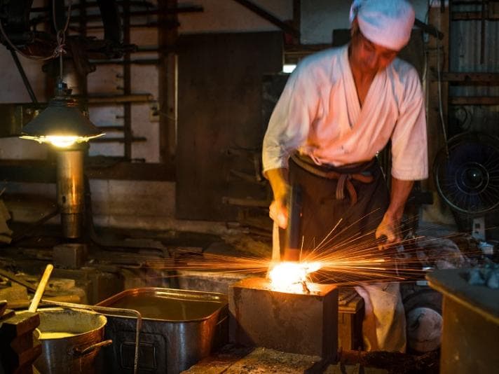 Man hammering metal on an anvil