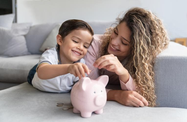 Mother and daughter using a piggy bank