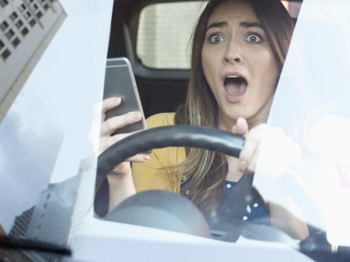 Woman using phone while driving car