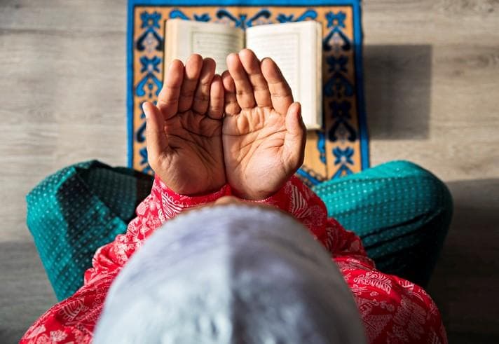 a Muslim praying with the Koran