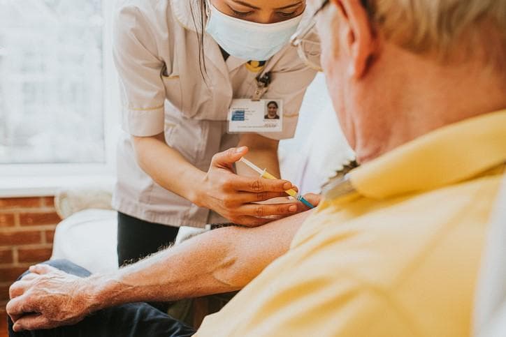 man getting a vaccination from a nurse