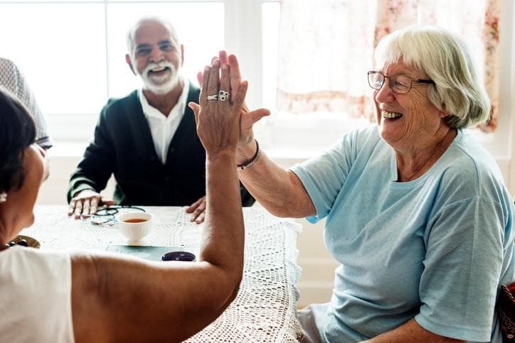 older adults high fiving in a care home