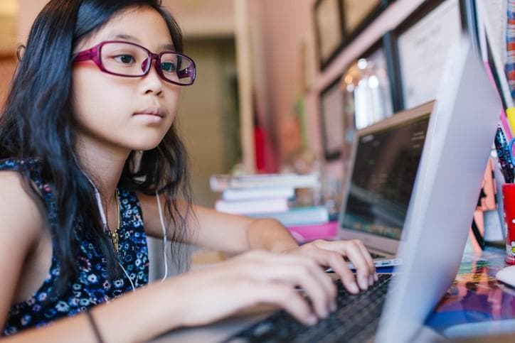 young girl using her laptop at home