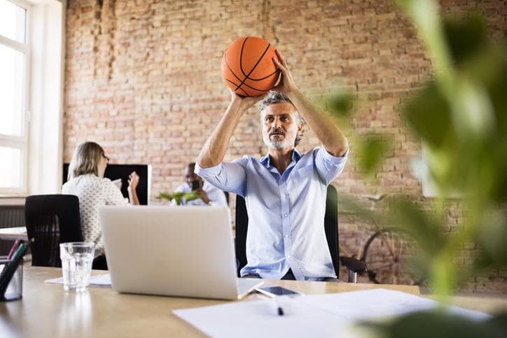 Businessman playing basketball in the office