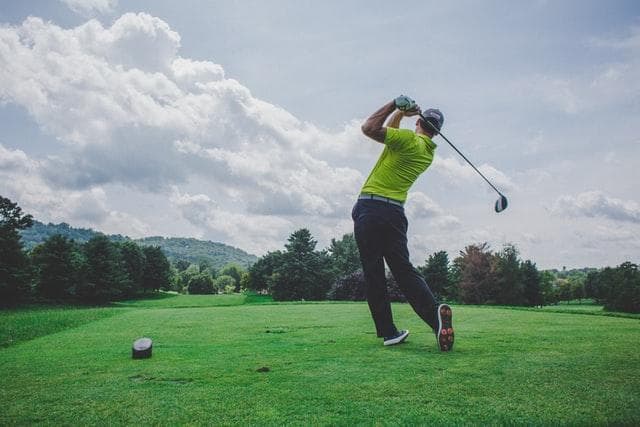 man standing holding a golf club