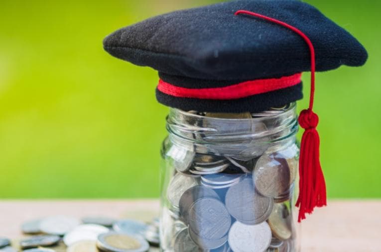 Graduation cap on top of a jar of money