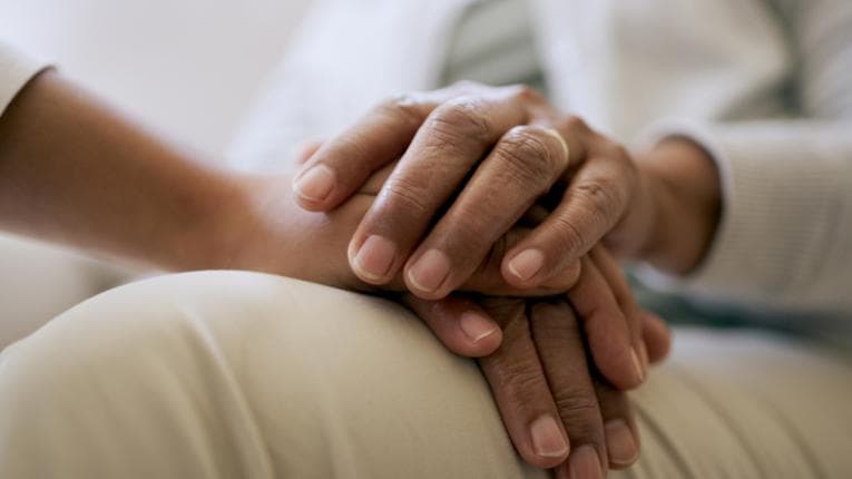 Hands together resting on lap