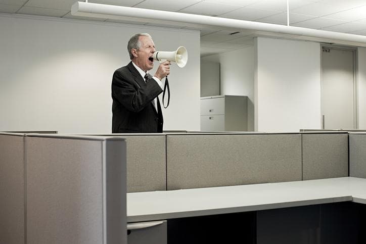 Man in empty office with speakerphone