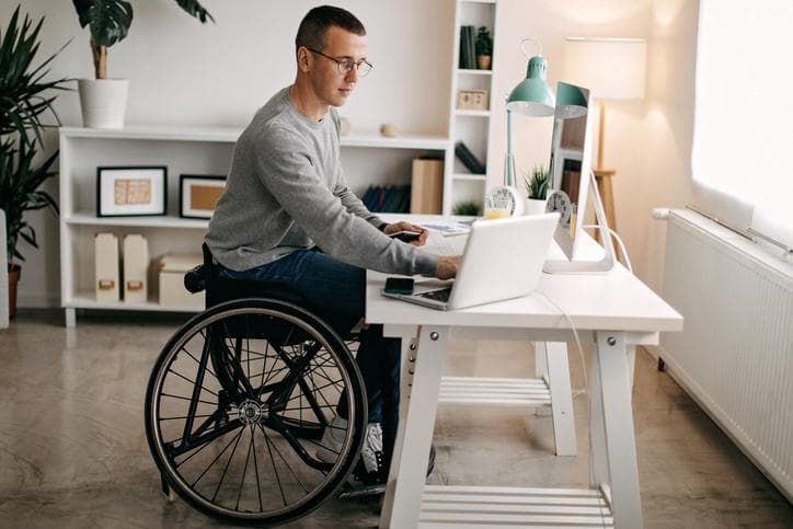 Man in wheelchair working at desk