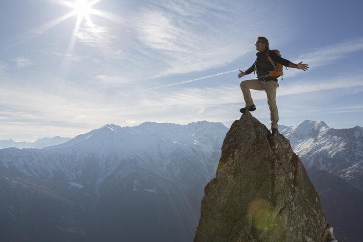 Man standing on the summit of a mountain