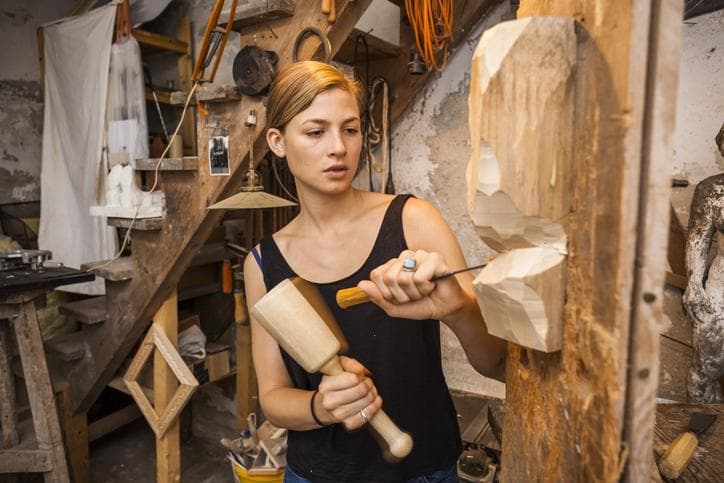 Sculptor carving wooden figure