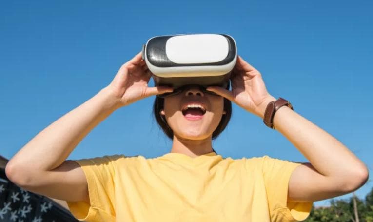 Smiling girl wearing virtual reality headset