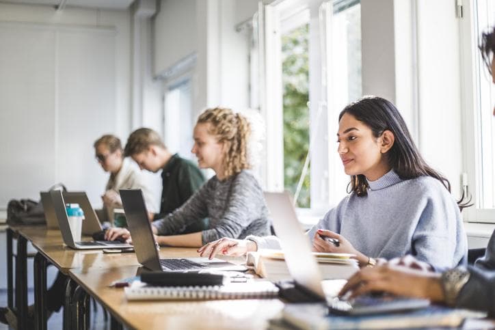 Students sitting in classroom with laptops