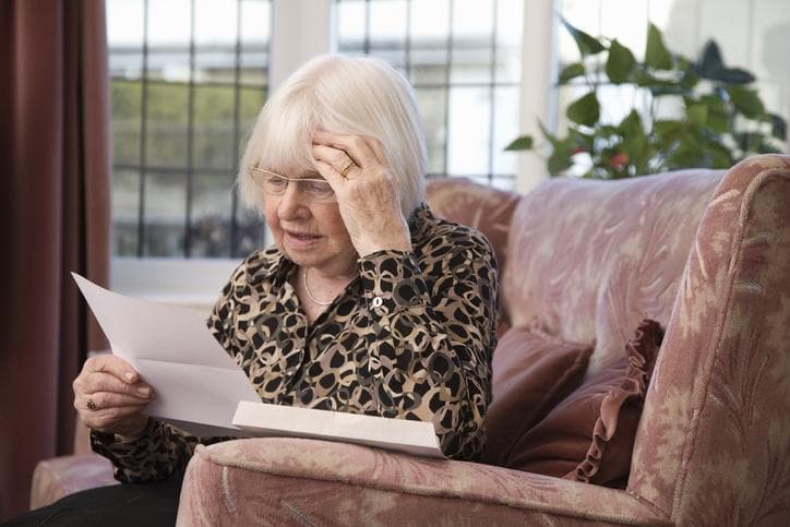 Woman sitting alone reading a letter