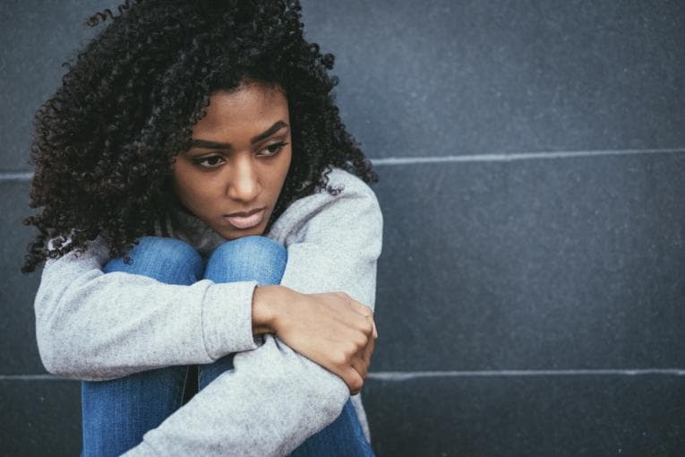 Woman sitting looking upset