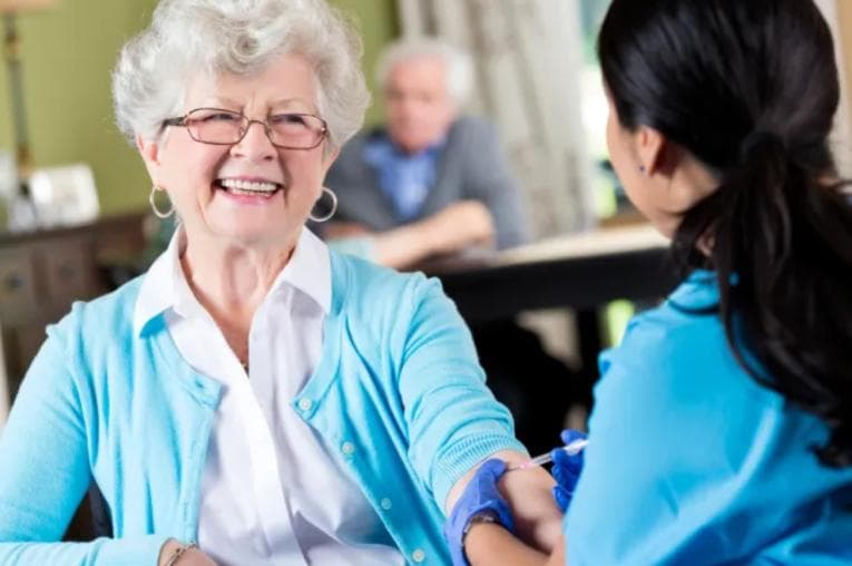 Smiling elderly woman receiving an injection