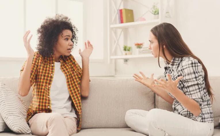 Two women on a sofa, arguing