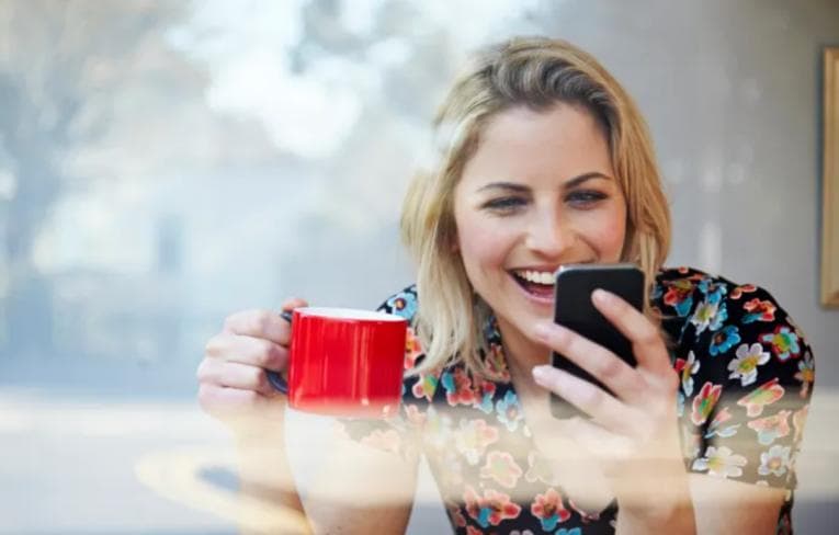 Woman laughing at something on her smartphone