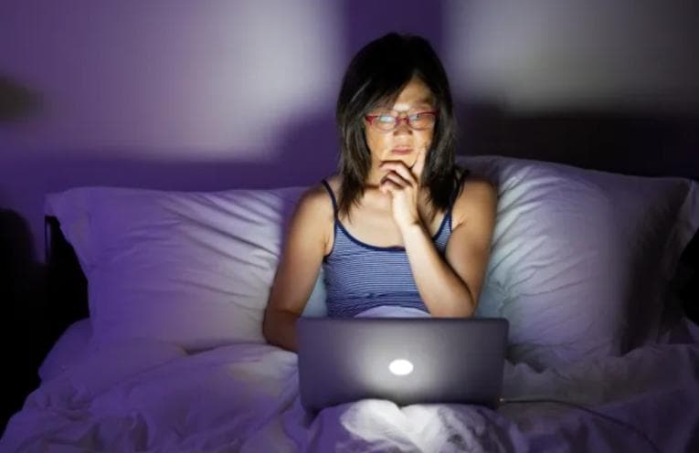 Woman using laptop late at night