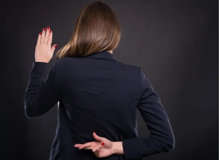 Woman with her fingers crossed behind her back