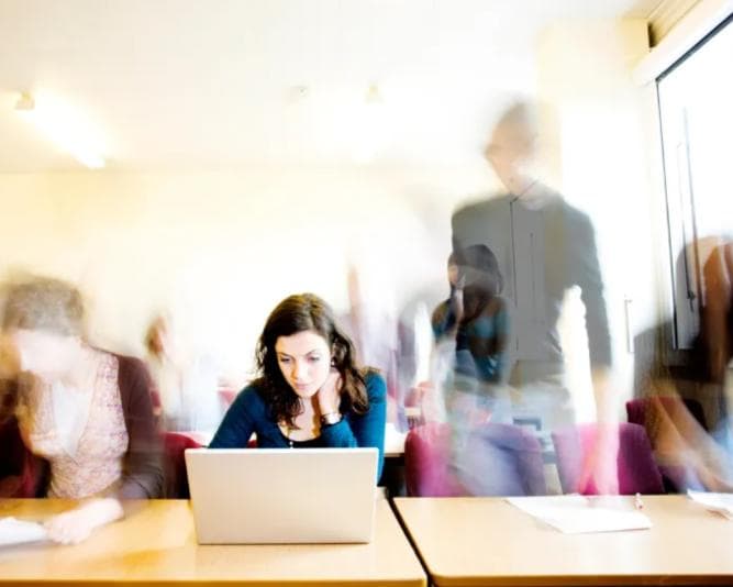 Young woman surrounded by after-images of other students