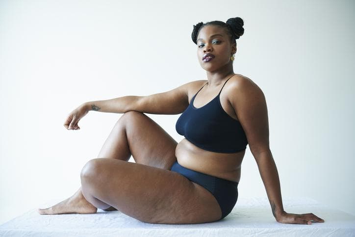 Confident curvy woman sitting and looking at the camera