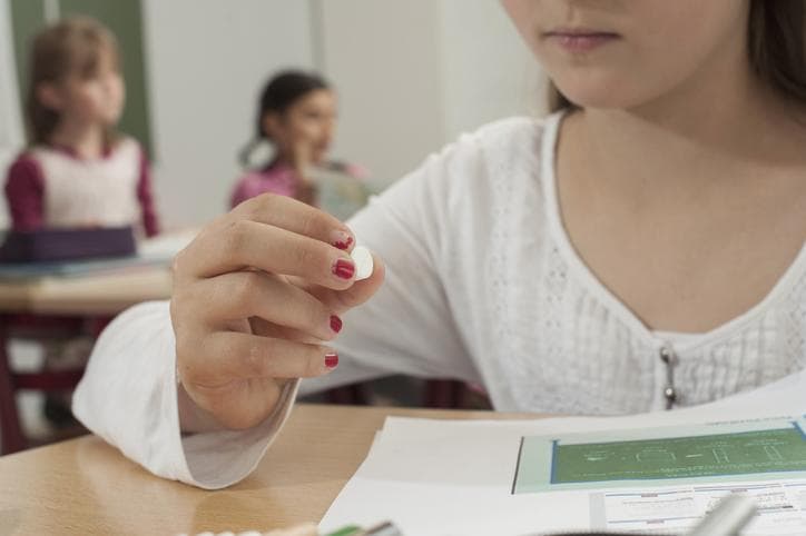 Schoolgirl holding a pill