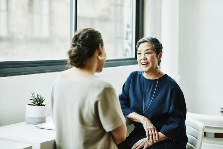 Two women speaking by the window in office