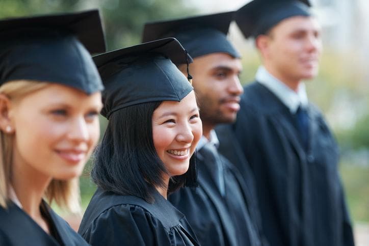 Young adults at graduation smiling