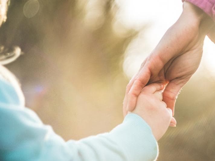 child holding parent's hand