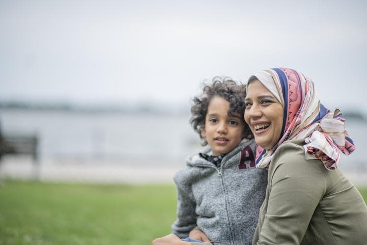 Muslim mother and her son embrace and enjoy time in the city together.