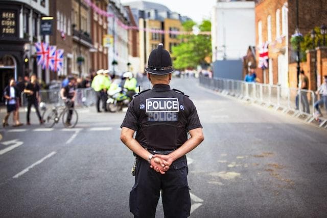 Back of a police officer standing in road