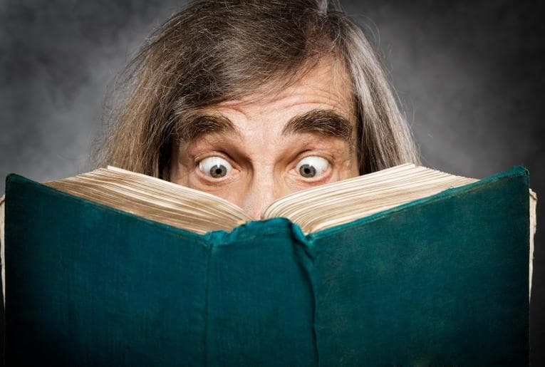 Man looking shocked reading a book