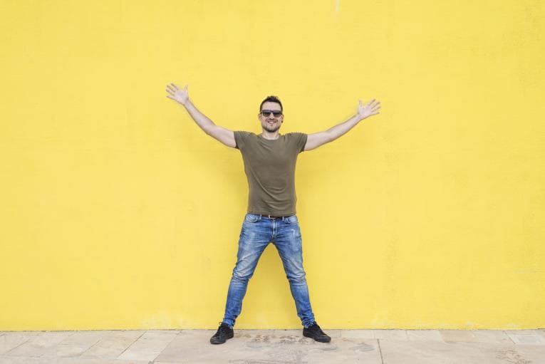 Man standing with arms raised and legs apart