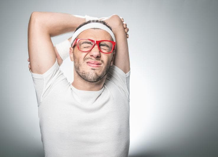 Grimacing man stretching before exercise