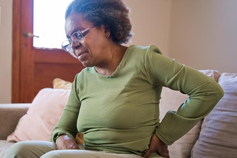 Woman holding her lower back in pain