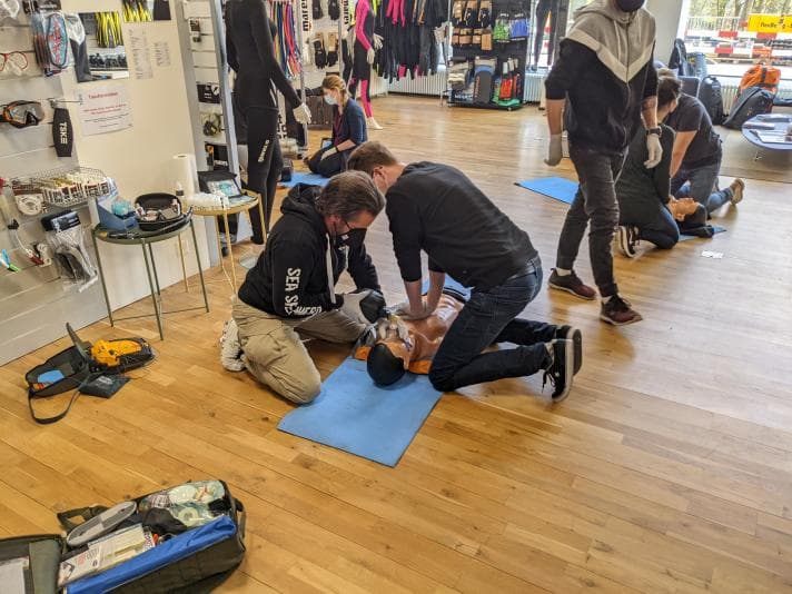 Men kneeling on floor training in emergency response